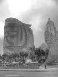 Fountain by building against sky in city