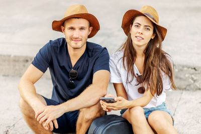 Portrait of smiling friends sitting at beach