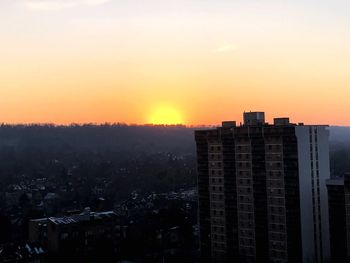 Silhouette buildings against clear sky during sunset