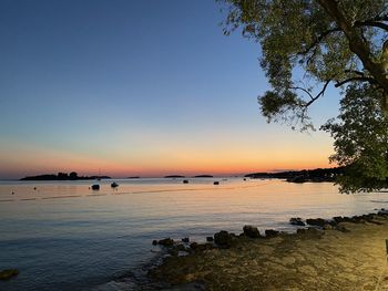 Scenic view of sea against clear sky at sunset