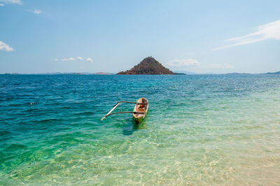 Man surfing in sea against sky