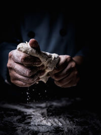 Close-up of man kneading dough