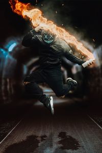 Man in black with light up mask and fire