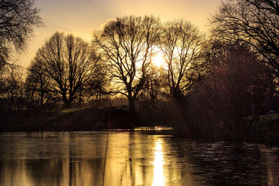 Scenic view of river against sky at sunset