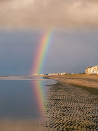 Scenic view of rainbow over sea against sky