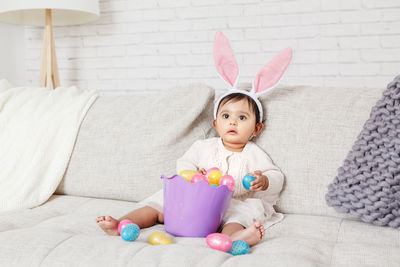 Cute girl wearing costume sitting on sofa