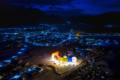 High angle view of illuminated cityscape against sky at night