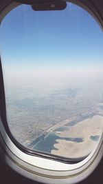 Low angle view of airplane wing over landscape