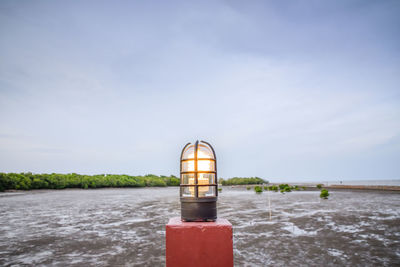 Close-up of lighting equipment on landscape against blue sky