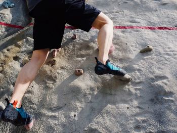 Low section of man climbing wall