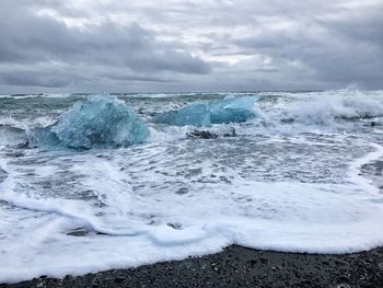 Scenic view of frozen sea against dramatic sky