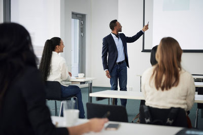 Businessman presenting before colleagues during meeting