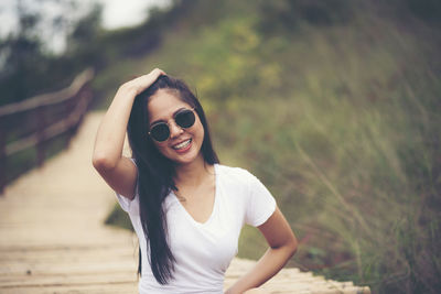 Portrait of smiling young woman wearing sunglasses outdoors