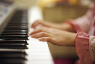 Close-up of hands playing piano