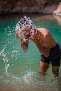 Water splash, a man washing his face with huge water splash near to his face at river 