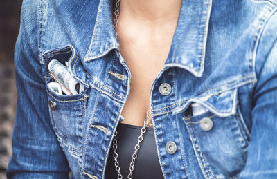 Midsection of woman wearing denim jacket