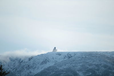Man on snow covered landscape against sky