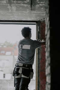 Caucasian male builder clean the window opening.