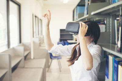 Female student using virtual reality simulator in library