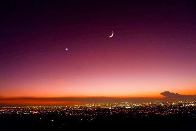 Silhouette cityscape against sky at night