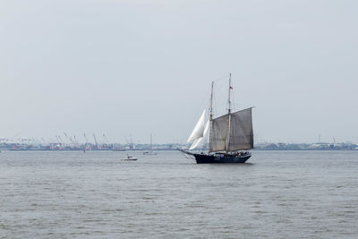 Sailboat sailing on sea against clear sky