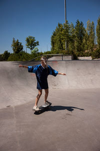 Full length of woman skateboarding at skateboard park