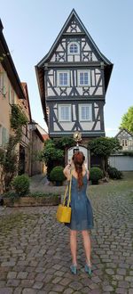 Full length of young woman standing against sky