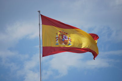 Low angle view of flag flags against sky