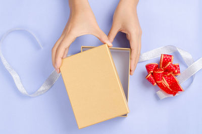 Low section of woman holding paper wrapped in box