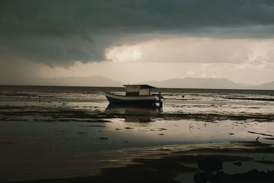 Boat moored on sea against sky