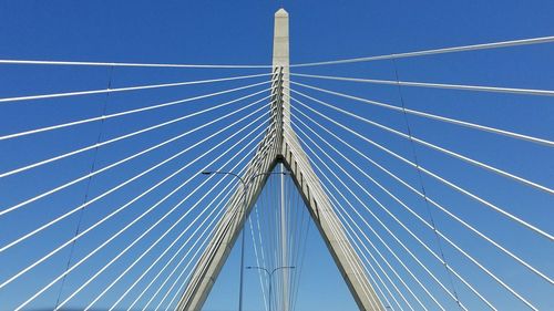 Low angle view of suspension bridge against blue sky