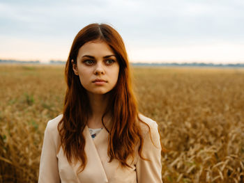 Portrait of young woman standing in field