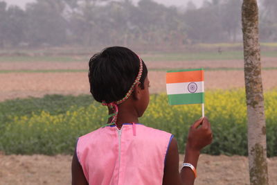 Full length portrait of woman standing on field