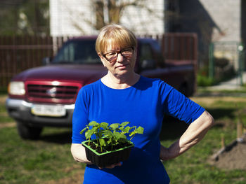 Portrait of man wearing eyeglasses standing against plants