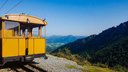 Train and mountains against clear blue sky