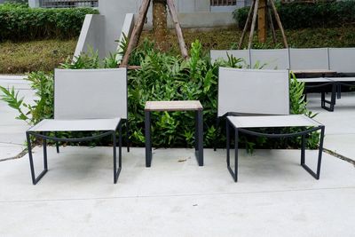 Empty chairs and table in yard