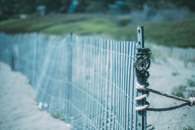 Close-up of metal fence by railing