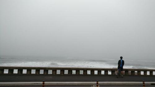 Man standing on beach against clear sky