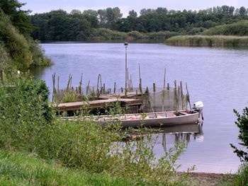 Boats moored in lake against sky