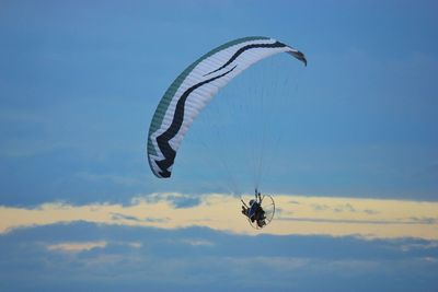 Low angle view of person paragliding against sky