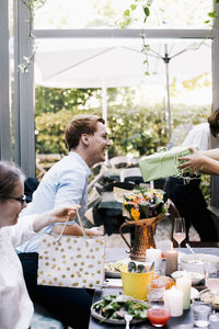 Happy son person taking gift from parent during party in restaurant