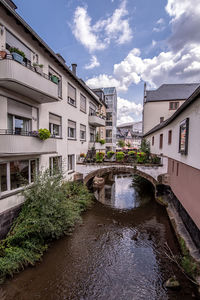 Canal amidst buildings against sky