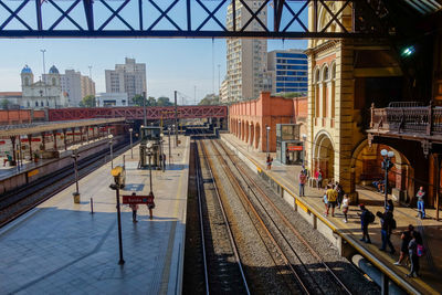 Train at railroad station in city against sky