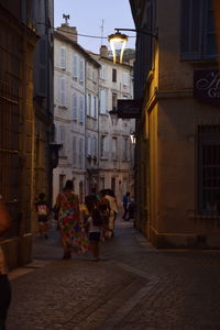 People walking on street amidst buildings in city