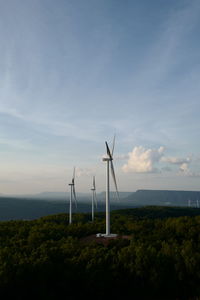 Windmills on landscape against sky