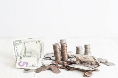 Close-up of coins on floor against white background