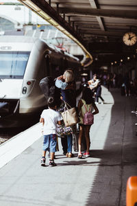 Children looking at parents embracing on train station