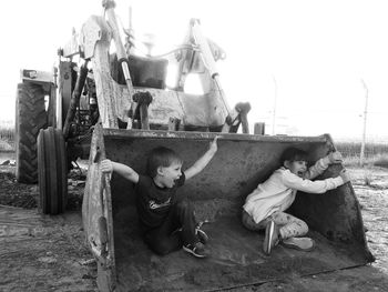 Happy siblings playing in earth mover