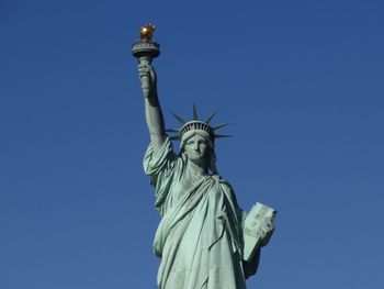 Low angle view of statue against blue sky