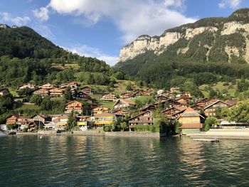 Scenic view of townscape by mountain against sky